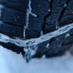 Snehové reťaze do auta nasadené na pneumatikách vozidla v zime