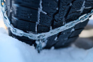 Snehové reťaze do auta nasadené na pneumatikách vozidla v zime
